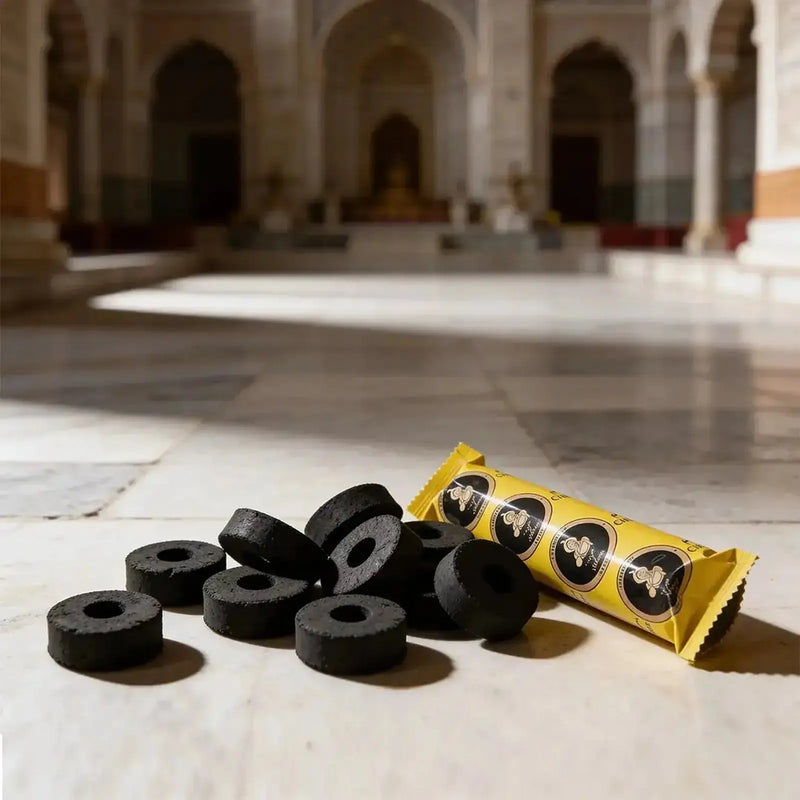 Zoura charcoal tablets and packaging on a marble floor inside a mosque