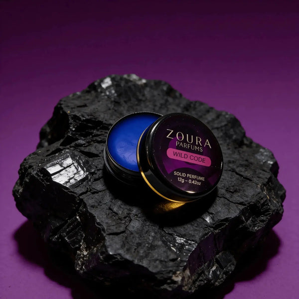 Zoura Wild Code Solid Perfume open jar on black rock