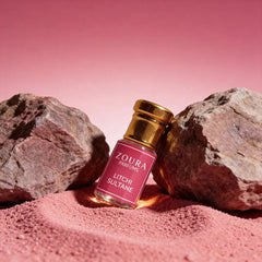 Zoura Parfums Litchi Sultane Attar bottle on pink sand with rocks – long lasting unisex attar