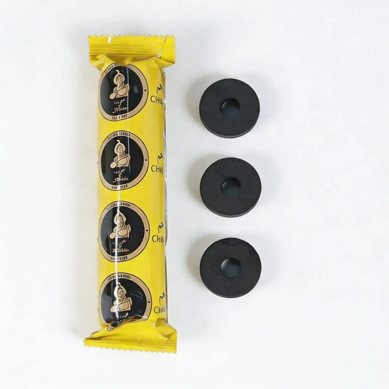 Yellow charcoal tablet package with round discs displayed on a white background