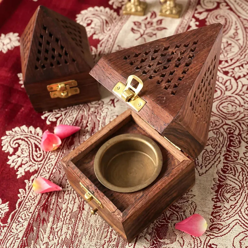 Wooden incense burner with a gold interior on a patterned fabric background