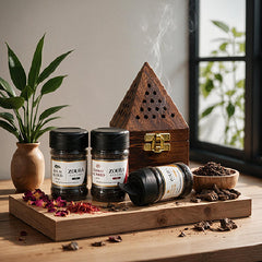 Zoura Parfums Diwan Bakhoor Trio with wooden bakhoor burner on a wooden tray by a window