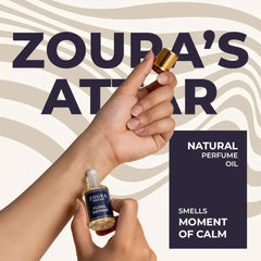 Zoura's natural perfume oil attar being applied to wrist – Floral Safrane bottle, smells like a moment of calm