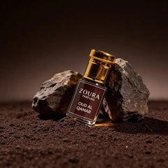 Zoura Parfums Oud Al Qamar oud attar bottle styled with rocks in warm desert-inspired lighting