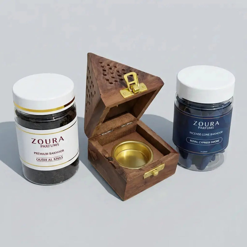 Two Zoura Perfumes products and a wooden bakhoor burner on a light gray background